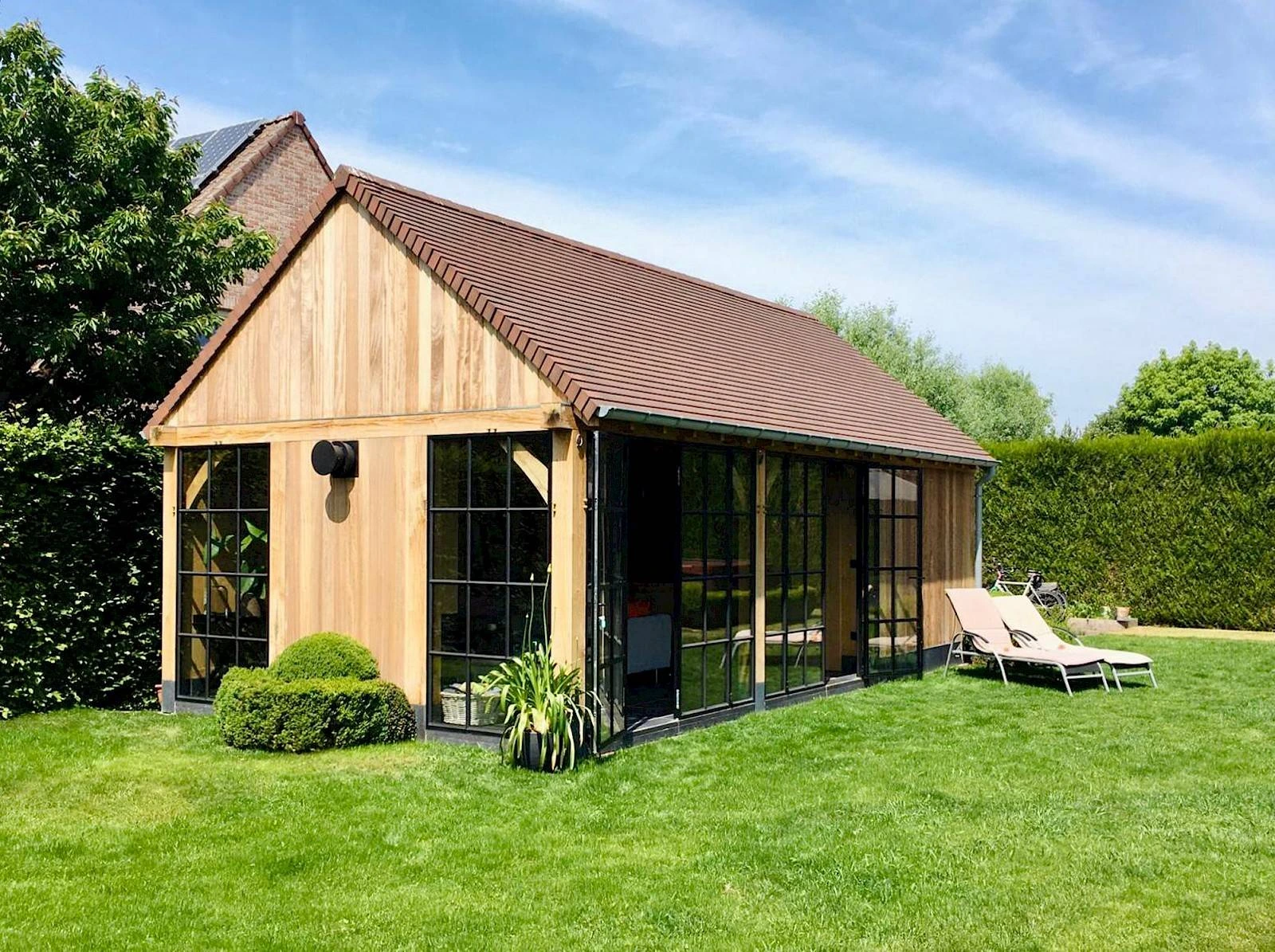 Tuinkantoor op maat in hout en staal in een groene tuin