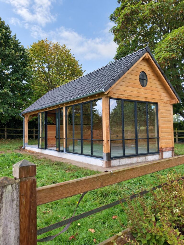 Houten tuinpaviljoen met zwarte stalen raampartijen