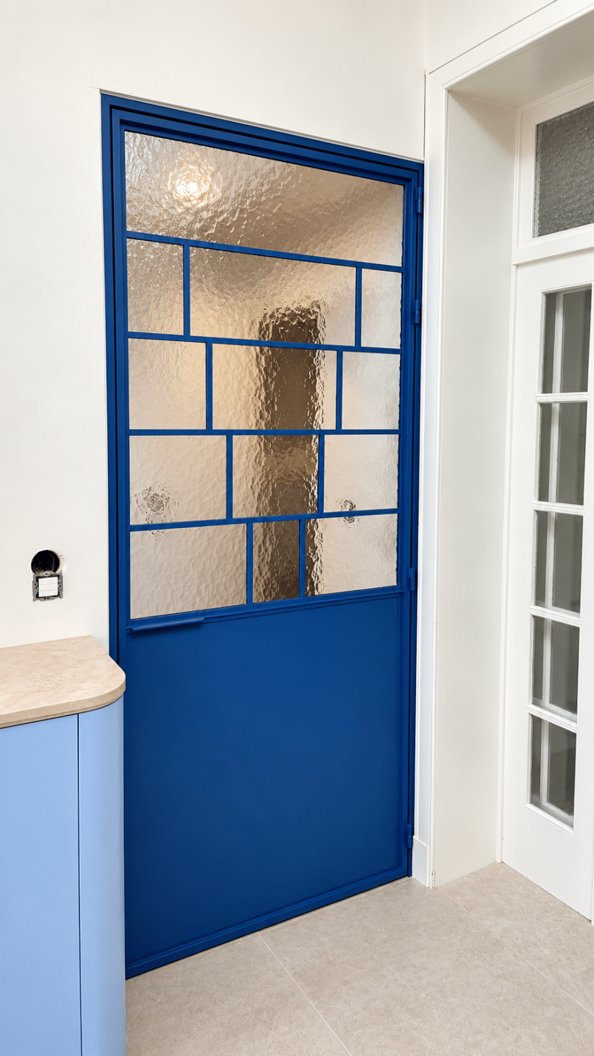 Blauwe stalen deur met roedeverdeling en structuurglas